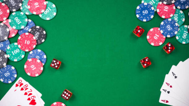 Casino games related items on green table, copy space.