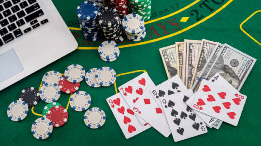 poker chips with banknotes placed on a laptop keyboard. Poker concept