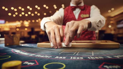 The croupier holds poker cards in his hands at a table in a casino.