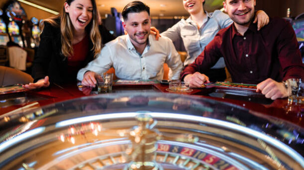 Excited group of friends playing roulette in casino