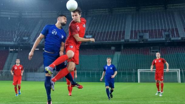 Football player jumping and heading the ball.